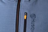 Close-up of a jacket with Husqvarna branding and a zippered pocket.