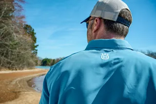 Personne de face à l’autre portant une chemise Husqvarna près d’un lac.