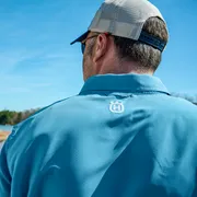 Personne de face à l’autre portant une chemise Husqvarna près d’un lac.