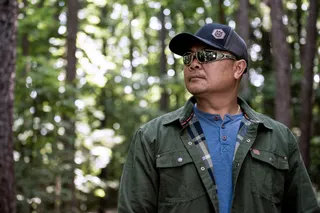 Person wearing work gear in a forest setting.