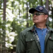 Person wearing work gear in a forest setting.
