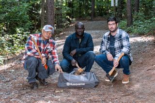 Three people in a forest setting with Husqvarna axes and a Husqvarna bag.