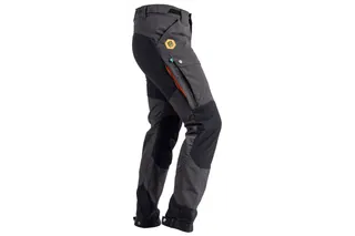 Pessoa virada para o lado a usar calças para motosserra Husqvarna.
