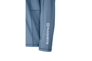 Gros plan d’une chemise à manches longues avec la marque Husqvarna sur la manche.