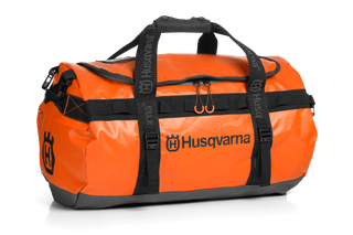 Vista frontal de um saco Husqvarna laranja com correias e logótipo pretos.