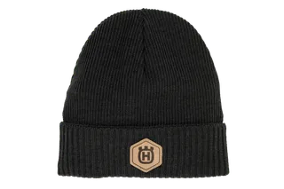 Front view of a knitted beanie with a logo patch on the cuff.