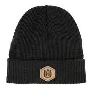 Front view of a knitted beanie with a logo patch on the cuff.