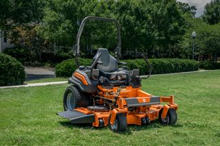 A Husqvarna ride-on mower parked on a grassy lawn, ready for use.