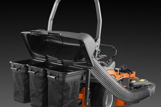 Rear view of a Husqvarna ride-on mower with open collection bins and hose attachment.