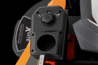 Close-up view of a control panel on a ride-on mower, featuring a dial and cup holder.