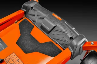 Close-up of a lawn mower's deck and footrest area.