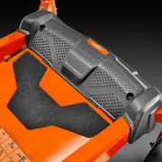 Close-up of a lawn mower's deck and footrest area.