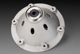 Top view of a metal component with a central bearing and multiple mounting holes.