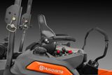 Панель керування й сидіння косарки-трактора Husqvarna крупним планом.