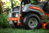 Close-up of a Husqvarna ride-on mower in a garden setting.