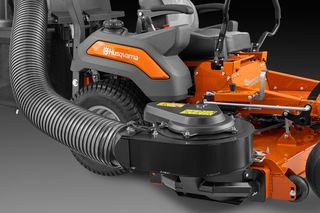 Close-up of a Husqvarna ride-on mower with a large hose attachment, showcasing its detailed components.