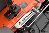 Vue rapprochée des composants mécaniques et des commandes d’une tondeuse Husqvarna.