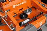 Close-up view of a Husqvarna mower's cutting deck and components.