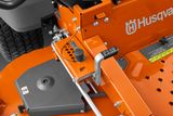 Close-up of a Husqvarna ride-on mower's cutting deck adjustment mechanism.