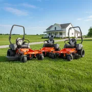 Three Husqvarna ride-on mowers parked on a grassy lawn in front of a house.