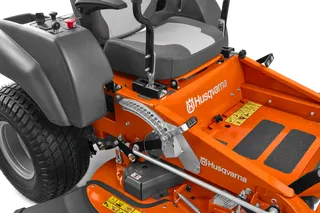 Close-up view of a Husqvarna ride-on mower's cutting deck and control levers.