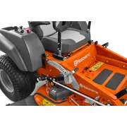 Close-up view of a Husqvarna ride-on mower's cutting deck and control levers.