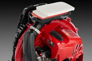 Side view of a leaf blower with visible air filter and engine components.