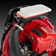 Side view of a leaf blower with visible air filter and engine components.