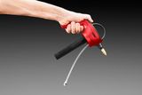 A hand holding a red nozzle with a hose attachment, possibly for spraying or dispensing.