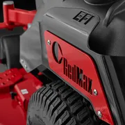Close-up view of a RedMax branded lawn mower with visible tire and deck components.