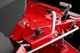 Close-up view of a ride-on mower's control panel and seat adjustment mechanism.