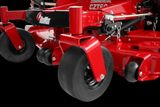 Close-up view of a commercial lawn mower's wheels and cutting deck.
